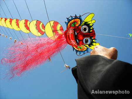 A contestant flies his kite featuring a centipede in Hankou, Central China's Hubei province, March 23, 2008. A kite flying contest with the theme of Beijing Olympics was held there. [Asianewsphoto]