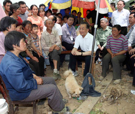 Chinese Premier Wen Jiabao comforts local people during an inspection in Muyu Township, Qingchuan County, southwest China's Sichuan Province May 15, 2008. Qingchuan County is one of the worst-hit areas in Sichuan Province. Premier Wen is here to oversee rescue work and visit survivors. (Xinhua/Yao Dawei)