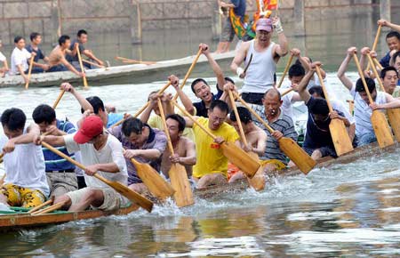 People practice paddling before a dragon boat race for the Dragon Boat Festival on the West Lake of Fuzhou, East China's Fujian province June 4, 2008.