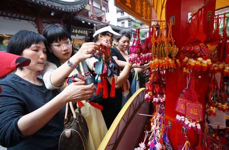 Visitors look at perfume pouches in front of a store in Shanghai June 4, 2008. People in some parts of China have a tradition of carrying these sachets during the Dragon Boat Festival, which falls on June 8 this year.