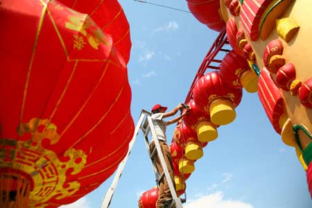 Villagers hang up red lanterns in Hongmiao Village of Huairou district, Beijing, capital of China, June 4, 2008. 