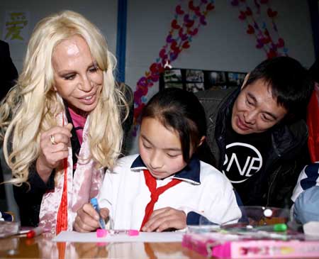  Italian designer Donatella Versace (L) and Chinese actor Jet Li watch a girl drawing at the Versace-One Foundation children center at Sanjiang, Wenchuan county, southwest China&apos;s Sichuan Province, Nov. 11, 2008. The center provides psychological consulting and therapy for children surviving the May 12 earthquake.