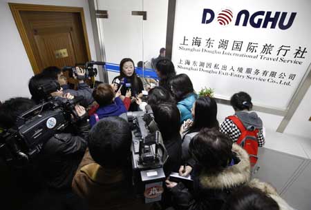A spokesperson of the Shanghai Donghu International Travel Service talks to reporters at the company in Shanghai Feb. 1, 2009. 