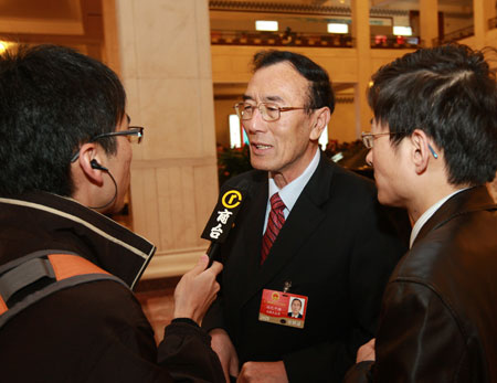 Qiangba Puncog (C), deputy to the Second Session of the 11th National People's Congress (NPC) from southwest China's Tibet Autonomous Region, receives interview prior to the third plenary meeting of the Second Session of the 11th NPC held at the Great Hall of the People in Beijing, capital of China, March 10, 2009. 