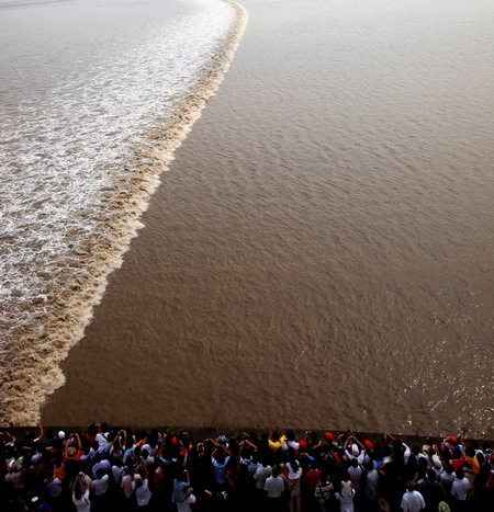 People watch tidal waves along Qiantang River