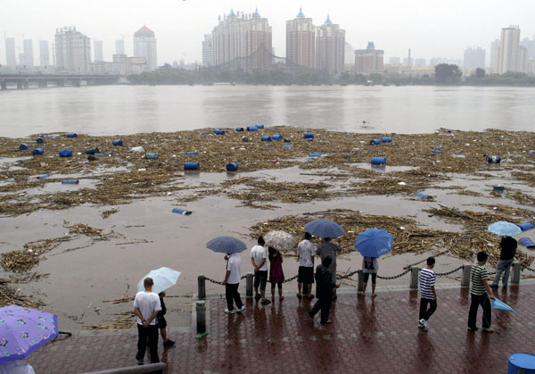 Workers struggle to retrieve barrels from river