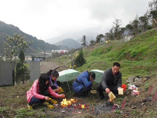 Relatives burn joss paper at the grave of an 11-year-old girl student at a local cemetery in Yingxiu town, the epicenter of the devastating Sichuan earthquake in 2008 that killed at least at least 68,000 people, in Wenchuan county of Southwest China's Sichuan province, on Sunday, April 3, 2011, two days before the Tomb Sweeping Day. In epicenter Yingxiu, the woe never dies