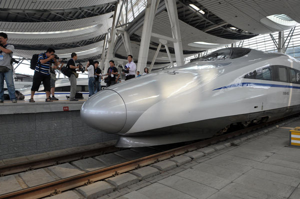 Photographers take pictures of a train before its trial run on the high-speed railway connecting Beijing to Shanghai, at Beijing South Railway Station, June 17, 2011. All aboard for 10 hours of speed and surprises