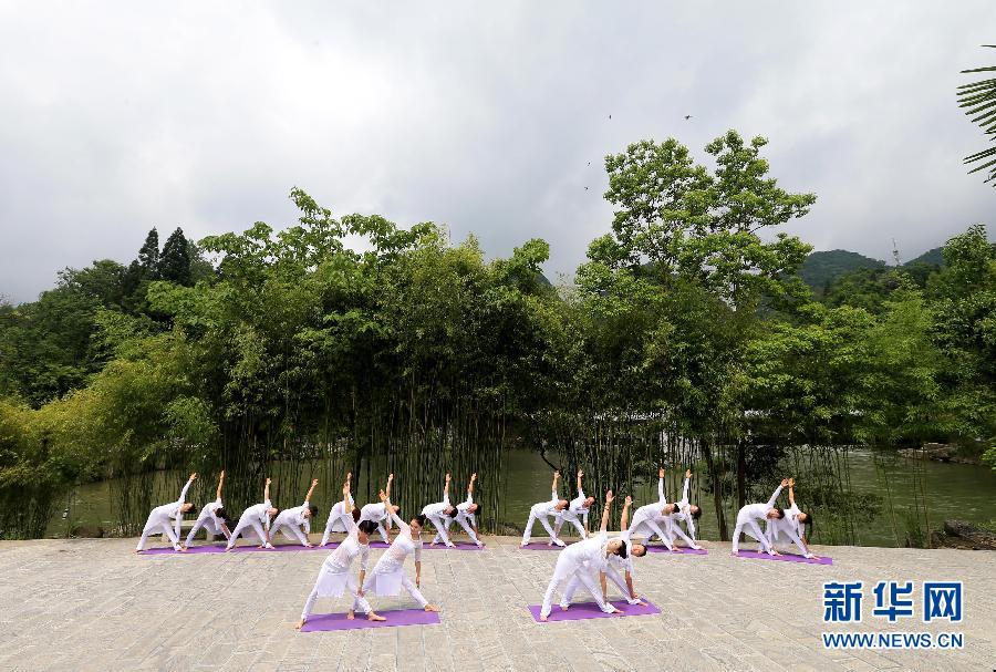 Practicing yoga among green hills and clear water