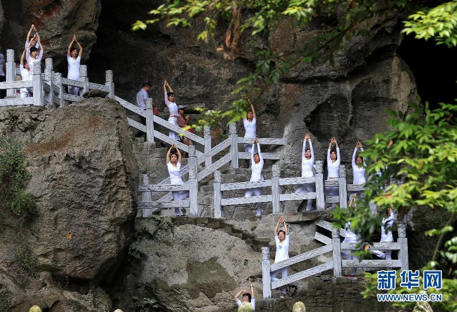 Practicing yoga among green hills and clear water