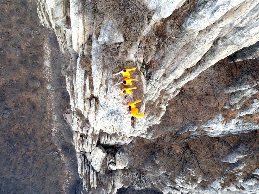 Martial artists practice Shaolin kung fu on cliff