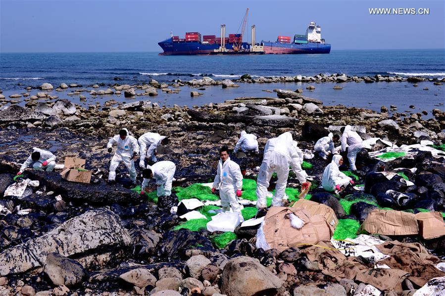 Workers clean up leaking oil on seaside of New Taipei city