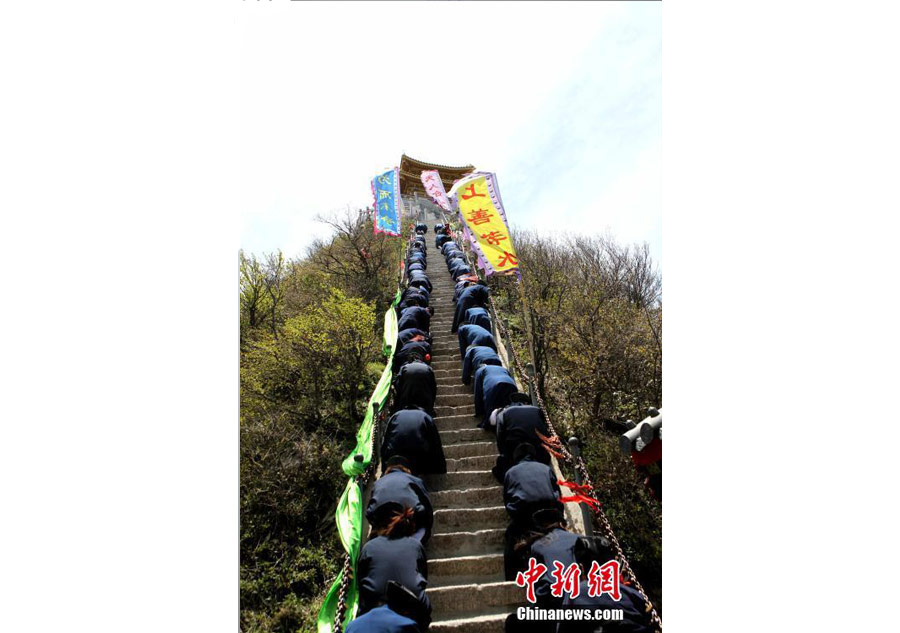 Taoist priests worship their ancestors by kneeling down on stone steps