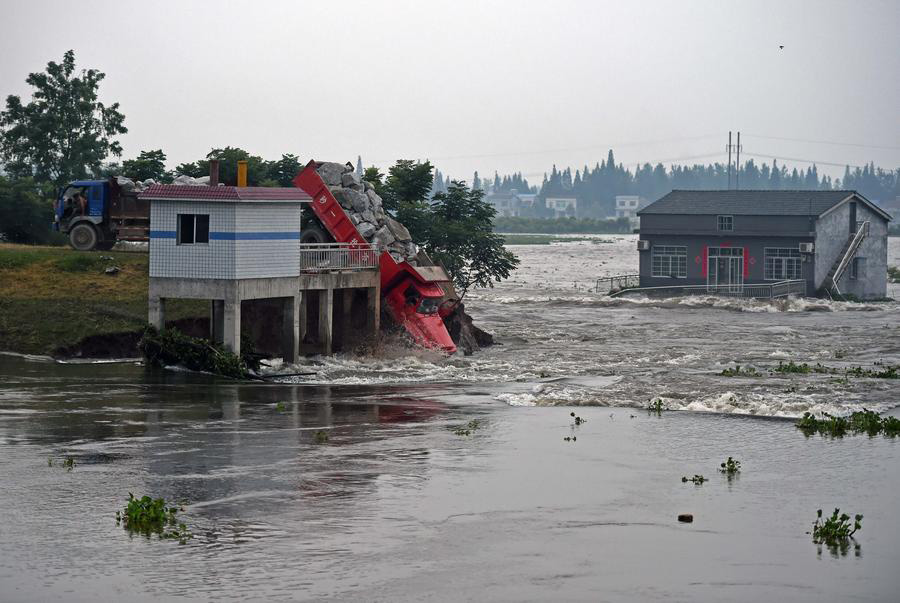 Rescuers risk life, drive heavy trucks to block floodwater