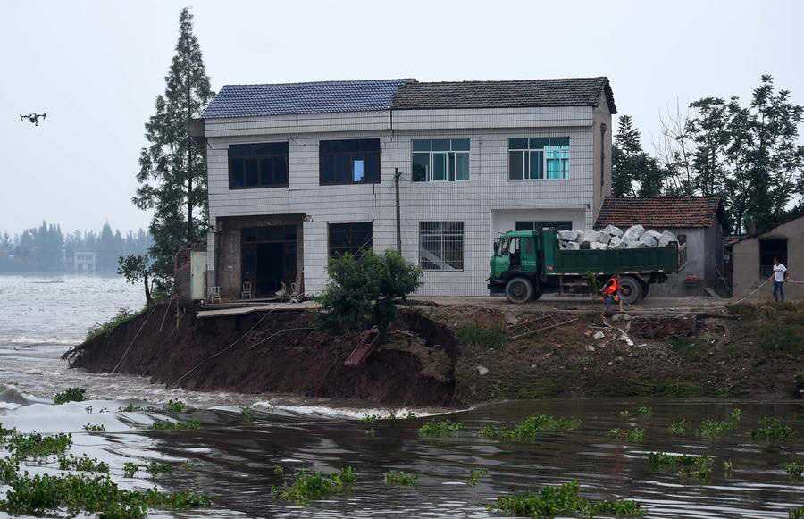 Rescuers risk life, drive heavy trucks to block floodwater