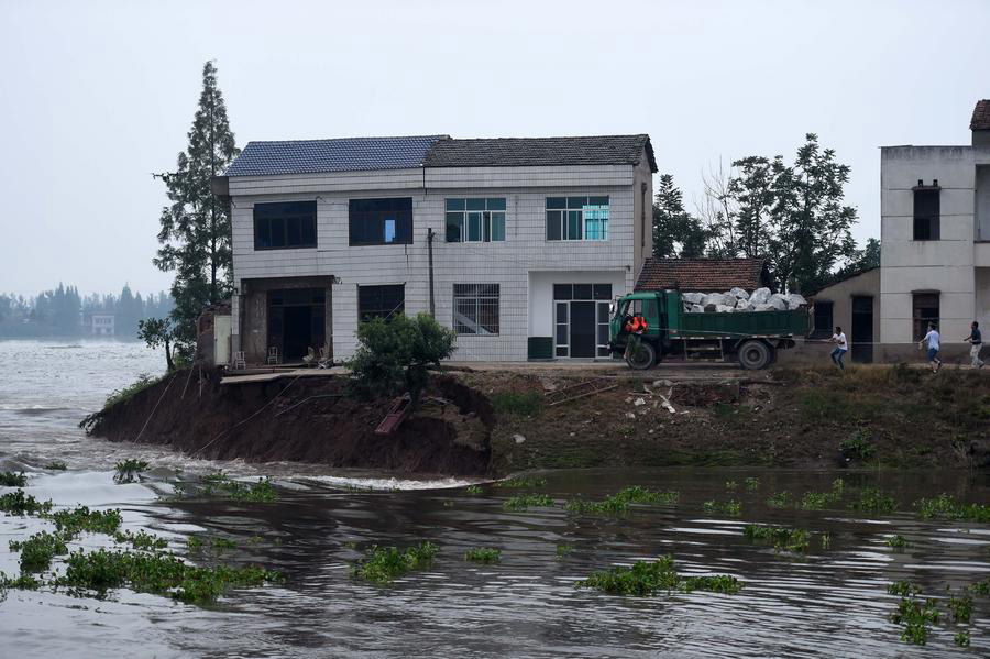 Rescuers risk life, drive heavy trucks to block floodwater