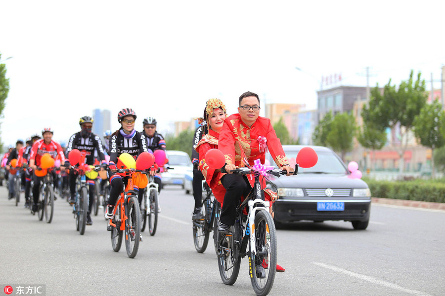 Groom and bride cycle their way to wedding