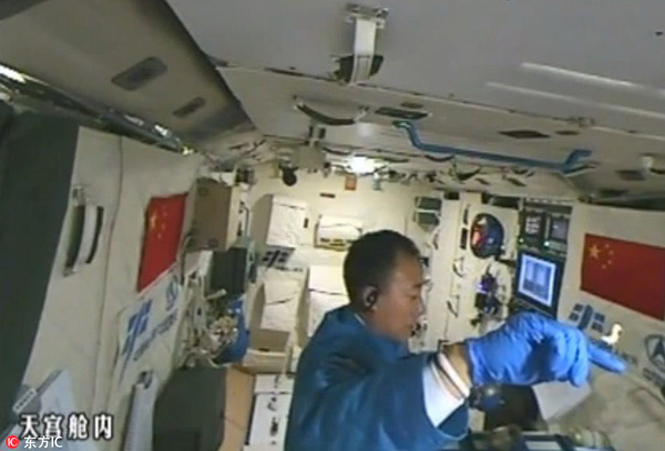 Astronaut plays with silkworms in Tiangong II