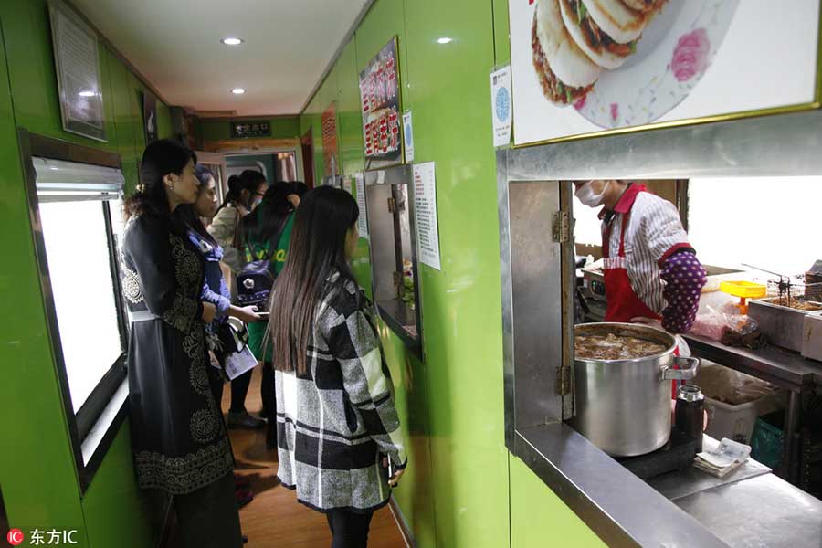 College students in E China enjoy meals in train-turned-canteen