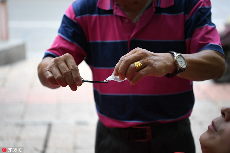 Flipping lids! Chinese barber offers eyelid shaves