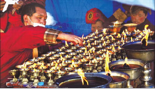 Butter lamps burn in memory of victims