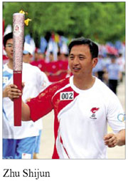 Police officer carries torch for quake victims