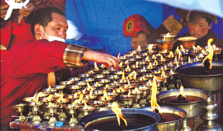 Butter lamps burn in memory of victims