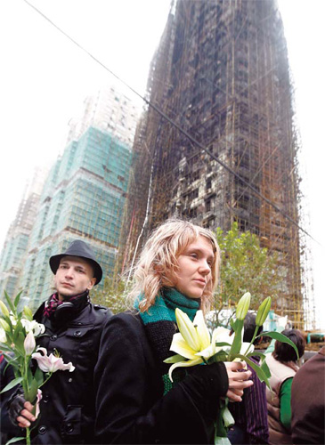 Flowers laid for blaze victims as city mourns