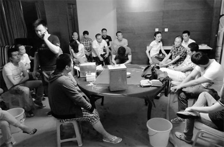 Suspects in an illegal gambling case sit in a hotel room in Shanghai ...