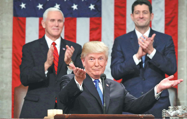 Trump warns of migrant peril, touts tax overhaul