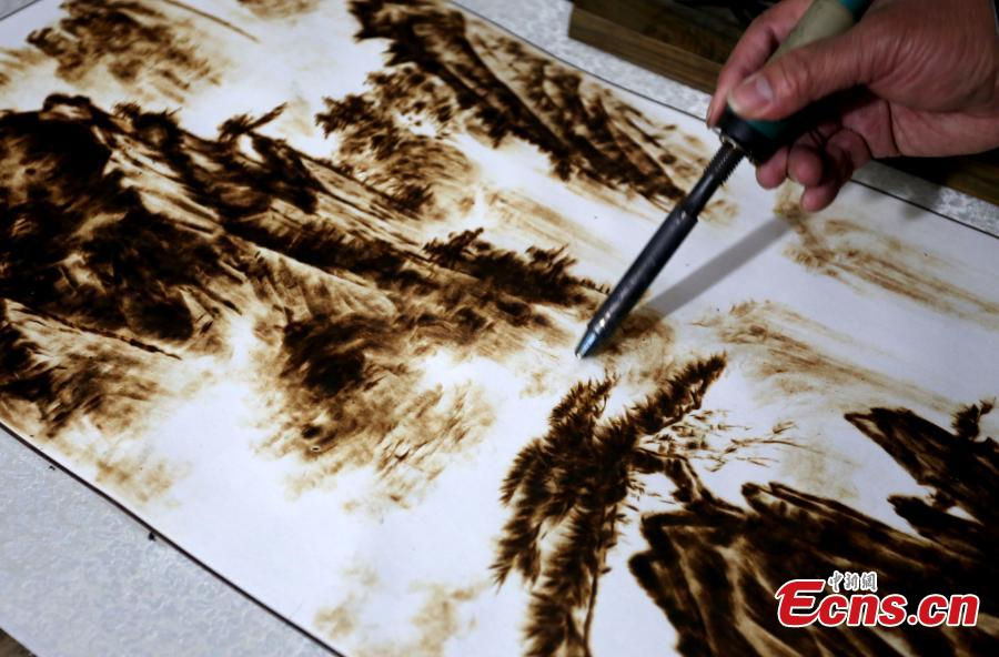 Folk artist turns electric soldering iron into drawing brush