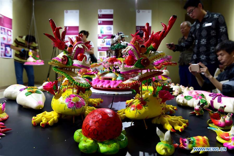 Delicate dough figurine work presented at craft workshop in Shandong