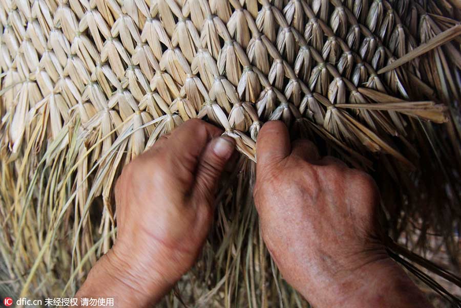 Woman keeps art of making straw rain cape alive