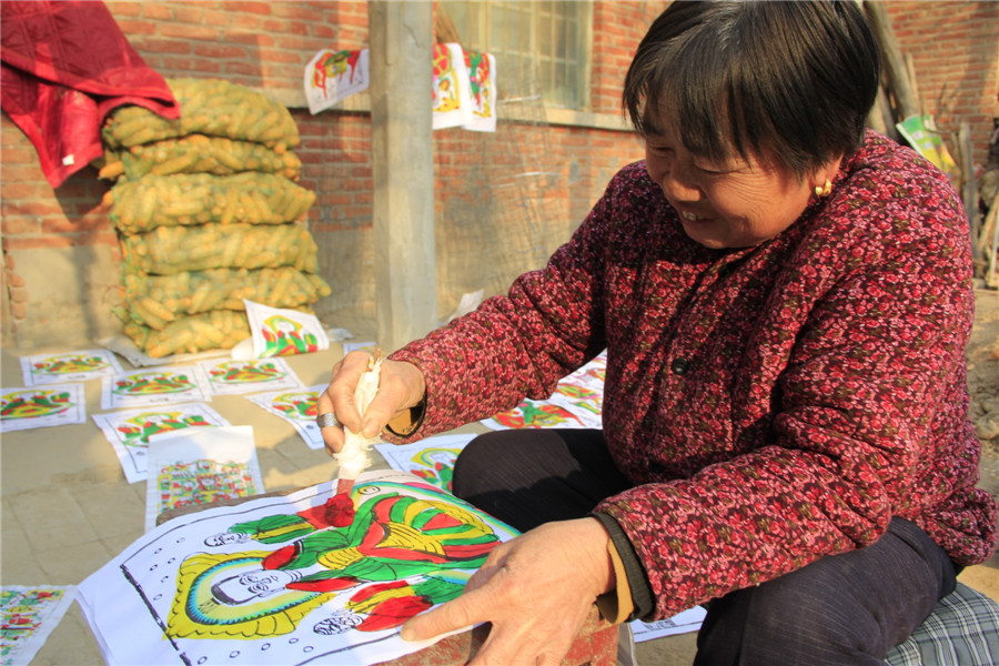 Folk artists create lunar New Year's woodblock paintings in C China