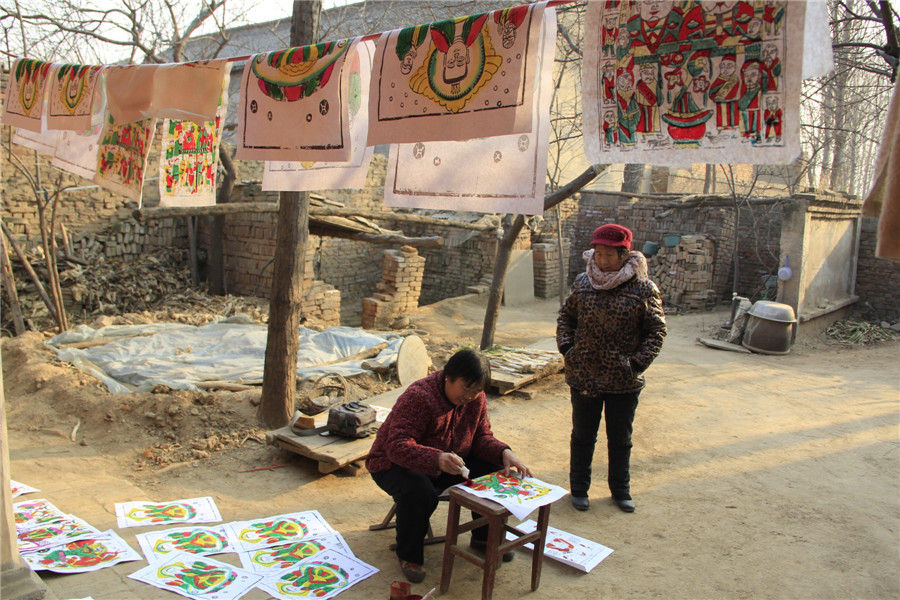 Folk artists create lunar New Year's woodblock paintings in C China