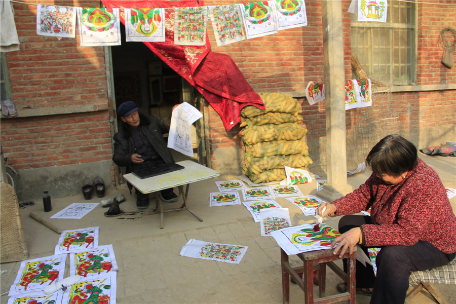 Folk artists create lunar New Year's woodblock paintings in C China