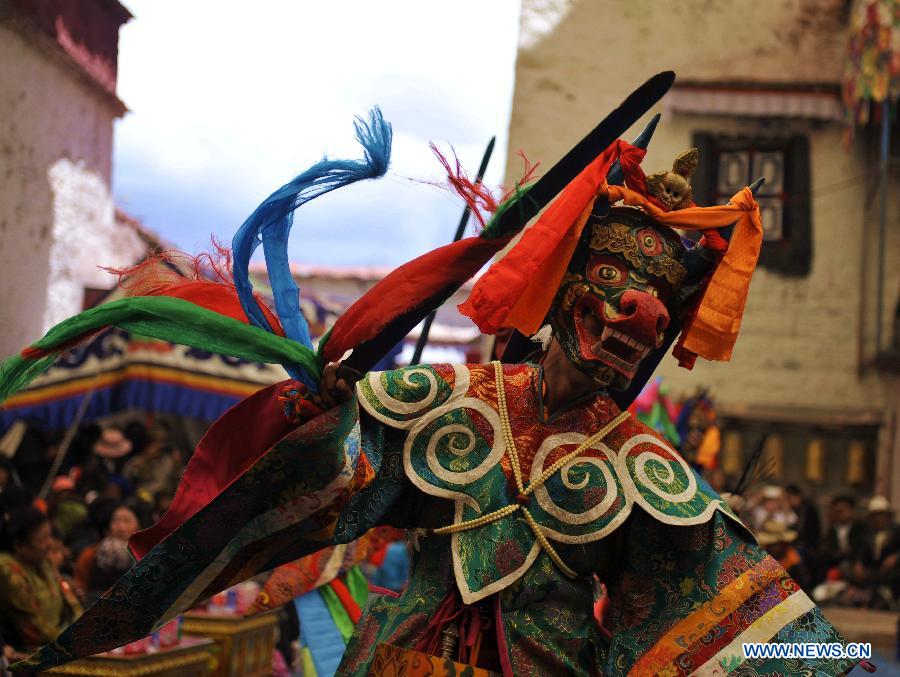 Tibetan Buddhist monks perform cham dance during ritual