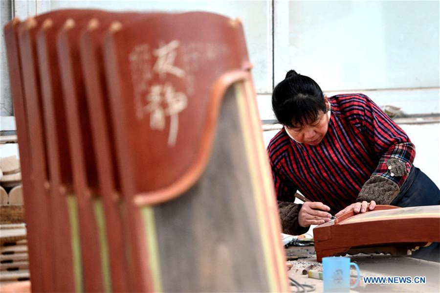 Workers make Chinese traditional music instruments Guzheng in Henan