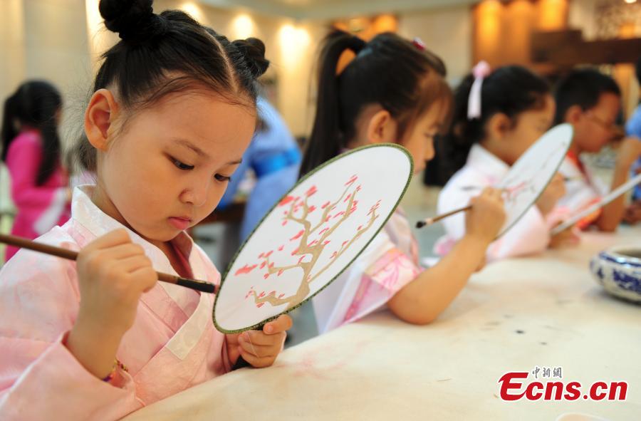 Children in traditional clothes experience classic Chinese culture