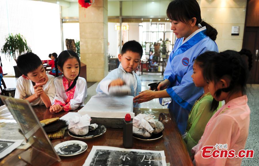 Children in traditional clothes experience classic Chinese culture