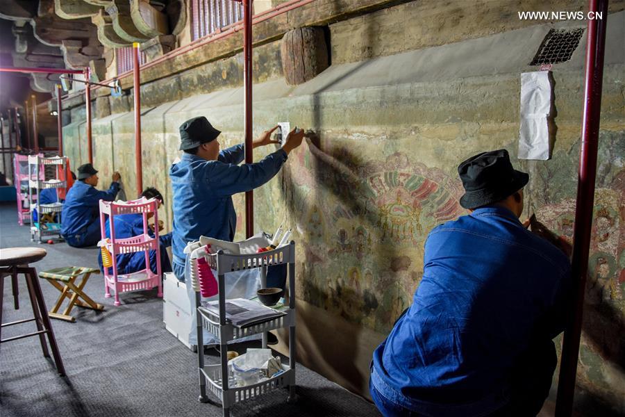 Experts restore ancient murals at temple in N China