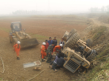 道路土质疏松致使挖土机翻落 司机被困车内