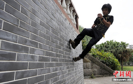 重庆男子练成“拇指禅” 灯杆上玩“漂浮”