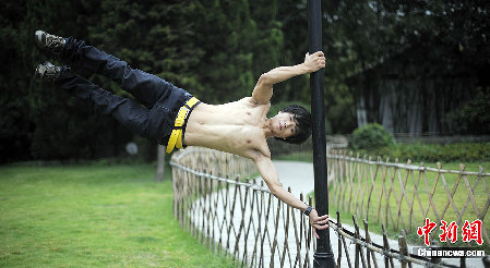 重庆男子练成“拇指禅” 灯杆上玩“漂浮”