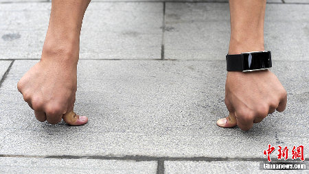 重庆男子练成“拇指禅” 灯杆上玩“漂浮”