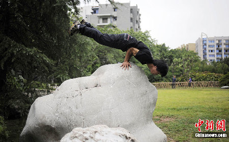 重庆男子练成“拇指禅” 灯杆上玩“漂浮”