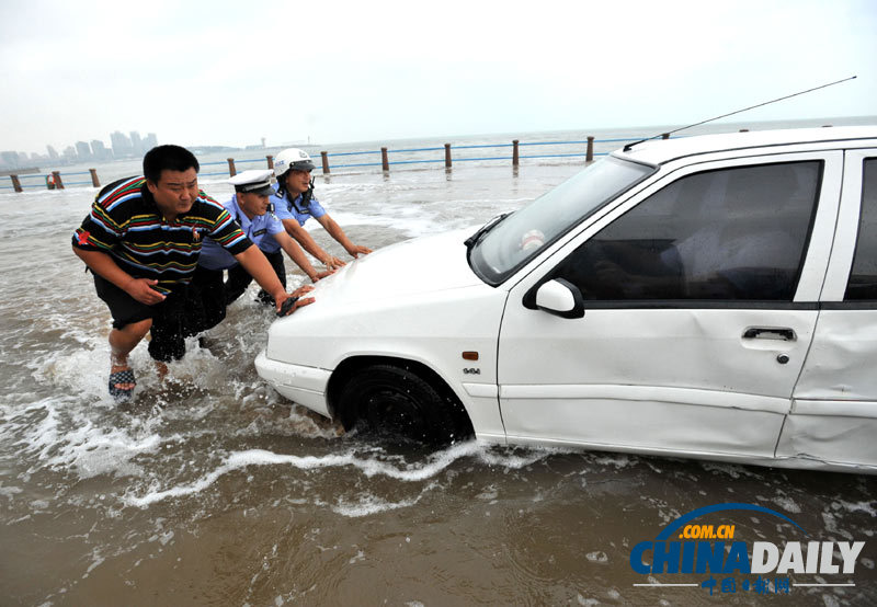 台风袭来青岛海域掀巨浪 民警斩浪救车