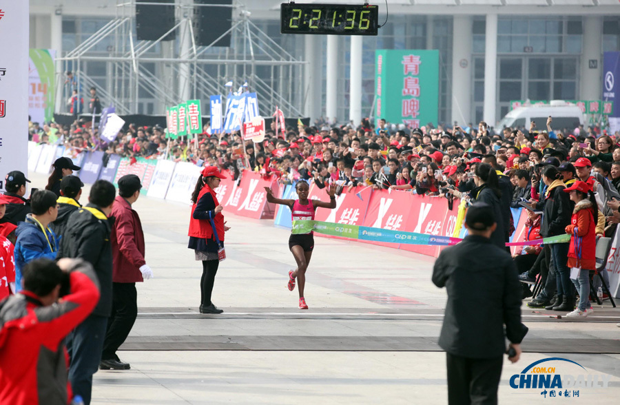 万人齐跑厦门马拉松 一选手冲刺抽筋被搀扶