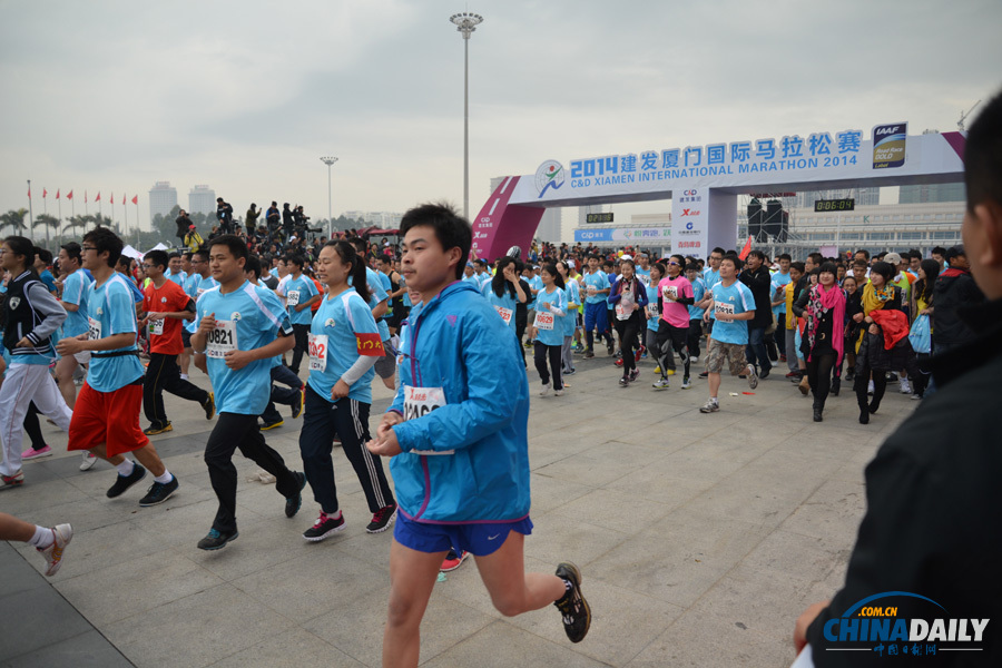 万人齐跑厦门马拉松 一选手冲刺抽筋被搀扶