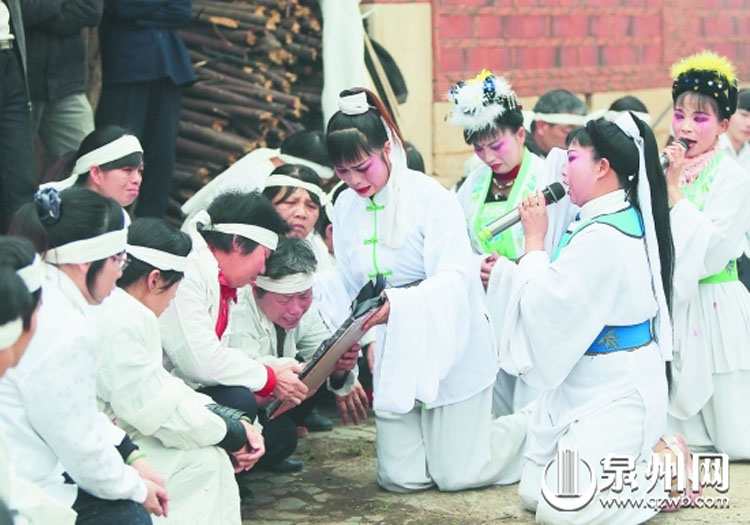 即将出殡,哭灵人在祖祠前一边哭灵一边手捧遗像与亲属泪别死者.